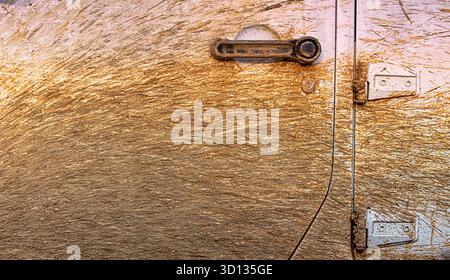 Off road vehicle body and door handle covered in brown mud splatter, showing texture and grunge after an adventure Stock Photo