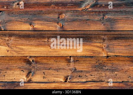 Old natural dark wood planks showing intricate grain patterns and knots, creating a rustic and organic surface texture Stock Photo