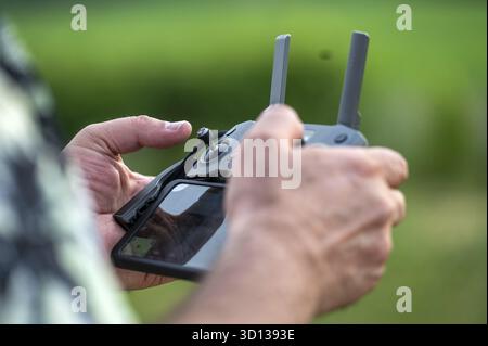 Close-up of a man holding a remote control of a drone, selective focus Stock Photo