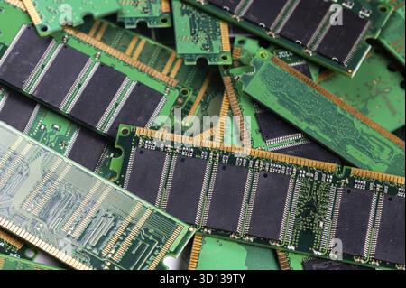 Various computer memory modules are piled on a green circuit board, showcasing technology Stock Photo