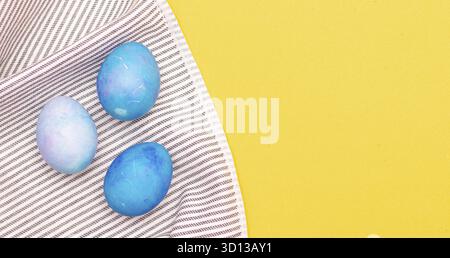 Blue painted eggs on a towel . The religious holiday is Easter. Eggs are seasonal in color. Blue painted eggs. Banner with a place under the text East Stock Photo