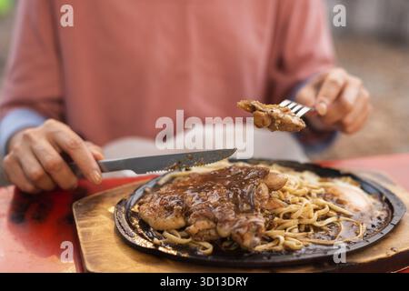 Woman eat Taiwanese night market steak at the street Stock Photo
