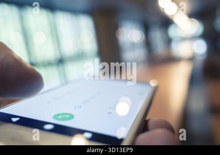 Using cellphone to dial, closeup image focus on the button Stock Photo
