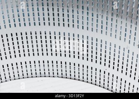 Perforated metal sheet showcasing an industrial texture with uniform slot patterns, forming an abstract background Stock Photo