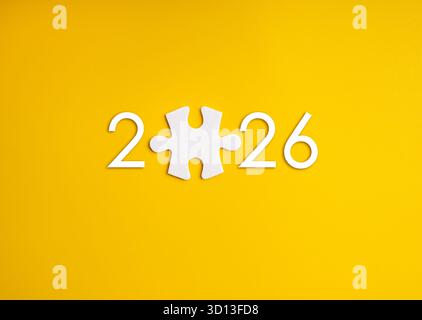 2026 number with white puzzle piece replacing zero on yellow background. Concept for business solution, finding missing piece, innovation strategy, pl Stock Photo
