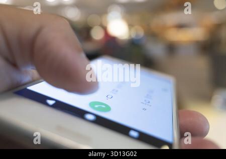 Using cellphone to dial, closeup image focus on the button Stock Photo
