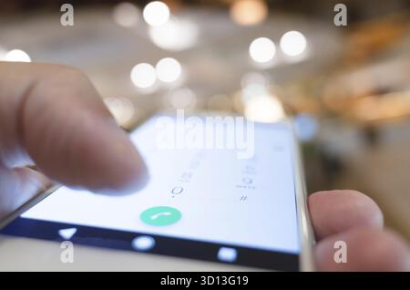 Using cellphone to dial, closeup image focus on the button Stock Photo