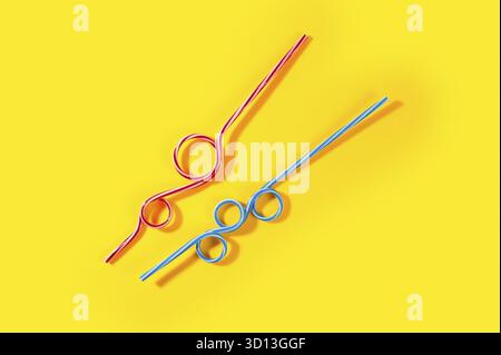 Plastic cocktail straws on yellow background Stock Photo