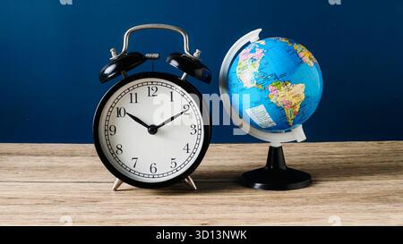 Vintage Alarm Clock and Small World Globe Symbolizing Global Time and Deadlines Stock Photo