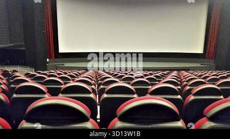 Rows of red plastic seats in empty cinema hall Stock Photo