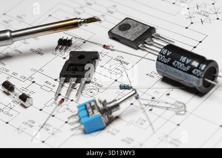 Various radio components and a soldering iron lie on a printed schematic diagram. Amateur radio concept, self-assembly of electronic devices Stock Photo