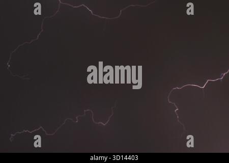 blurry lightning on cloud in dark sky at night white rain storm coming Stock Photo