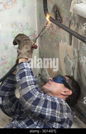 Installing new radiators with gas welding Stock Photo