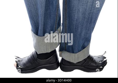 Object on white - men feet in blue jeans and Damaged old boots Stock Photo