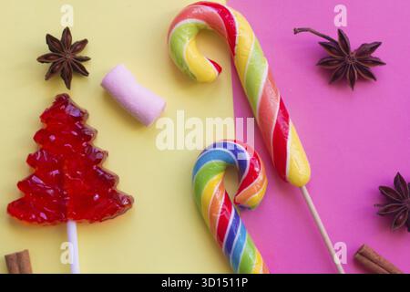 Lollipop on a gentle background. Christmas candy and caramel sticks on pink and yellow backgrounds Stock Photo