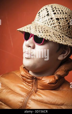 Young man in sunglasses with a red frame in a straw hat Stock Photo