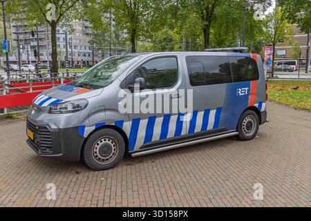 A grey van with blue and white diagonal stripes, clearly branded with the red "RET" logo for Rotterdam's public transport company, parked in a city ar Stock Photo
