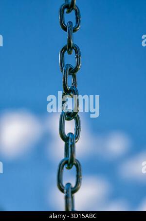 Links in a metal chain against a bright sky Stock Photo