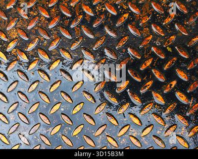 Detailed view of corrugated metal with textured surface, covered in warm orange rust, creating a weathered industrial background. Perfect for texture, Stock Photo
