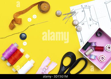 Layout sewing. needlework, craft, sewing and tailoring concept - box with thread spools and buttons on the table. The concept of sewing accessories. F Stock Photo