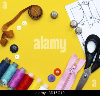 Layout sewing. needlework, craft, sewing and tailoring concept - box with thread spools and buttons on the table. The concept of sewing accessories. F Stock Photo