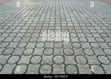 Hexagonal cement paving pattern forming geometric texture in diminishing perspective. Selective focus. Stock Photo
