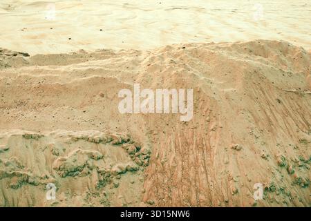 Closeup texture of dry beach sand with natural patterns and small ridges formed by wind and water erosion. Selective focus. Stock Photo