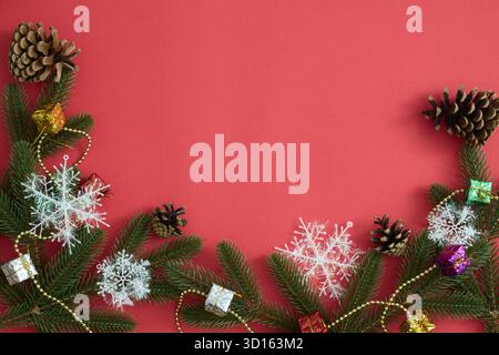 Christmas decorations: snowflakes, spruce branches, pinecones on red festive background Stock Photo