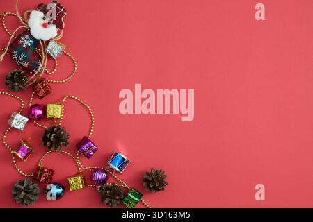 Christmas tree ornaments and pinecones on red festive background Stock Photo