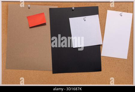 Cork board with hanging various blank colorful note leaves with copy space Stock Photo