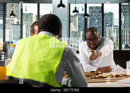 Real estate professionals using architectural software to refine housing layouts and 3D models. Development team collaborates on zoning regulations and property investment strategies. Stock Photo