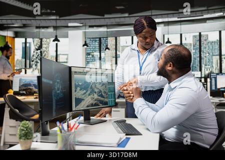 Engineering team uses AI to study next generation wind turbine technologies, accelerating clean energy adoption. Coworkers use artificial intelligence to optimizes aerodynamic design of VAWT turbine Stock Photo