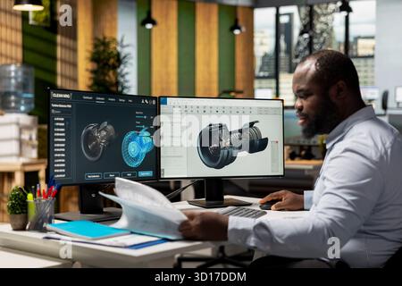 Technician in office reading wind turbine component documentation files to improve alternative energy efficiency. Researcher looking over paperwork documents to refine turbine part design Stock Photo