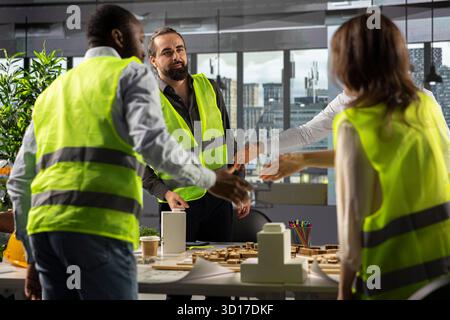 Architects and engineers collaborating on housing and city planning. Office scene shows teamwork, innovation and design as real estate experts plan residential project development. Stock Photo