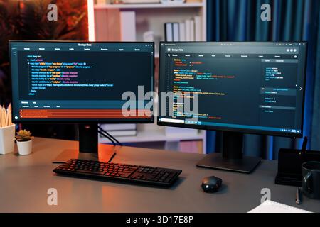 Programming code on computer two screens on desktop placing working desk showing intelligent website development coder system running data online info Stock Photo