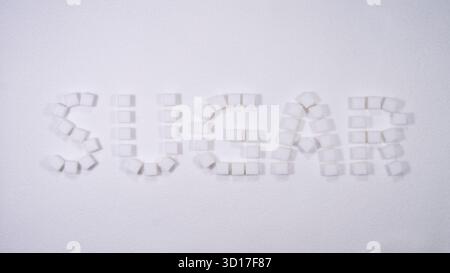 Creative arrangement of sugar cubes forming the word sugar on a white background suitable for educational or culinary themes Stock Photo