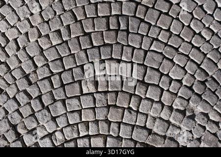 A textured cobblestone pavement arranged in a curved pattern Stock Photo