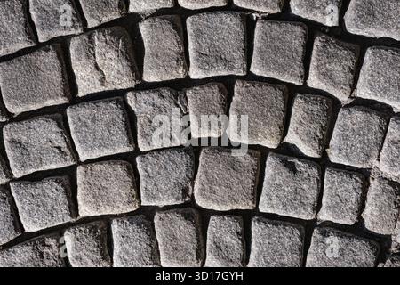 A textured cobblestone pavement arranged in a curved pattern Stock Photo