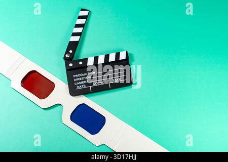 A cinematic composition featuring a clapperboard and 3D glasses against a vibrant, teal background, perfect for movie and cinema themes. Stock Photo