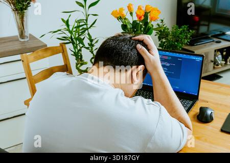 A man sits at a laptop and uses AI, seen from behind. High quality photo Stock Photo