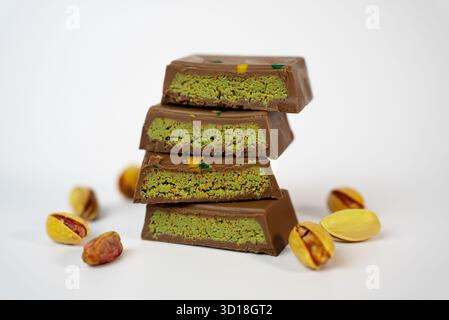 Artistic macro photo of stacked pistachio chocolate bars with nuts, ideal for luxury dessert branding and product packaging. Stock Photo