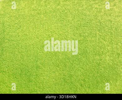 Terry towel or carpet of green color. Background with fluffy towel terry cloth. Natural cotton fabric texture. Long pile canvas. Close-up of soft cott Stock Photo