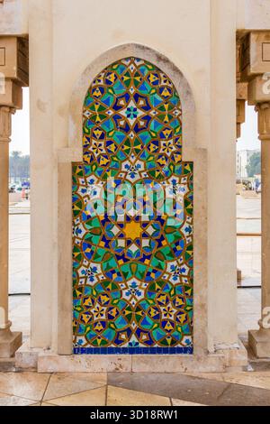 Traditional Moroccan mosaic ornament with geometric patterns and bright colors on the wall of the mosque. Stock Photo