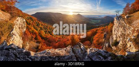 Scenic landscape Slovakia, on beautiful autumn sunrise with colorful leaves on trees in forest and bizarre pointy rocks on mountains valleys. Stock Photo