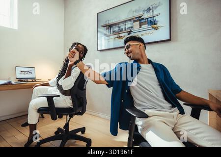 A male and female coworker enthusiastically working together at a small architecture firm, fostering collaboration and creativity in a professional an Stock Photo