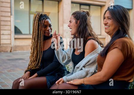 Diverse women friends talking laughing street toulouse Stock Photo