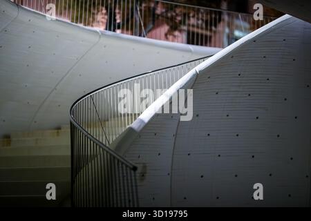 Spiral Ascent: Curved Staircase and Wavy Wall at Night Stock Photo
