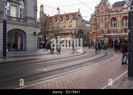 People and cyclists in Leidseplein, Amsterdam, Netherlands, on a cold winter day after the rain. In the background are the American Hotel and the International Theater Amsterdam. Stock Photo