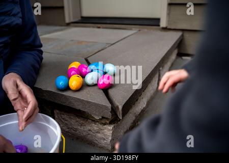 Colorful Plastic Easter Eggs on Step Outside of Home with People Stock Photo