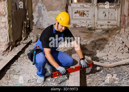 Construction worker using a level tool in a dusty room Stock Photo